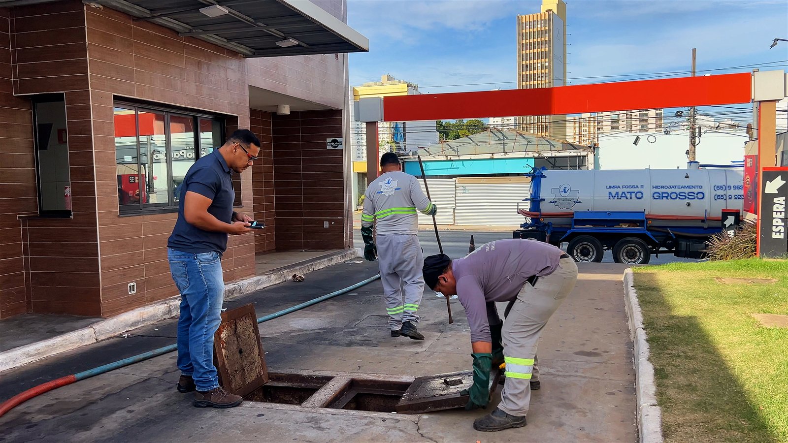 Equipe da Limpa Fossa Mato Grosso realizando serviço com caminhão ao fundo